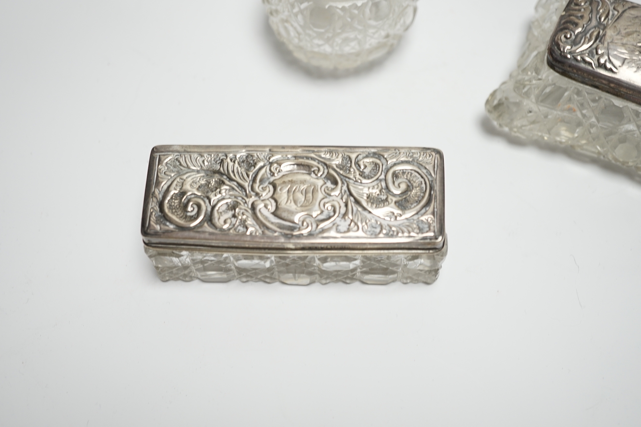 A late Victorian repousse silver mounted travelling pocket watch case, Birmingham, 1898, 11.6cm, with nickel cased pocket watch, together with five silver topped glass toilet jars.